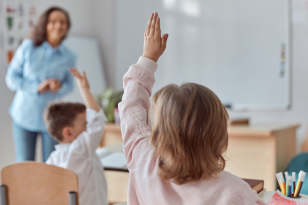 how-does-the-hub-works girl holding hand up and teacher looking at her